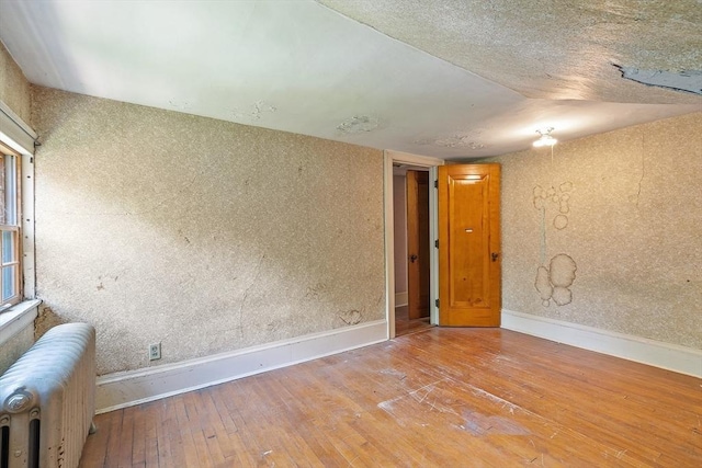 298 Highland St, Worcester, MA 01602 - spare room featuring radiator heating unit, hardwood / wood-style flooring, and baseboards