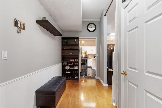 54 Forest St Unit 411, Medford, MA 02155 - corridor featuring light wood finished floors and a wainscoted wall