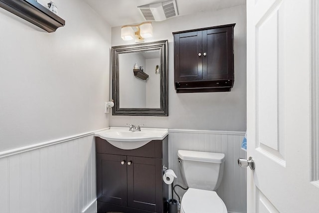 54 Forest St Unit 411, Medford, MA 02155 - bathroom featuring vanity, a wainscoted wall, and toilet