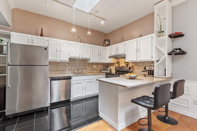 54 Forest St Unit 411, Medford, MA 02155 - kitchen with stainless steel appliances, open shelves, under cabinet range hood, a sink, and rail lighting