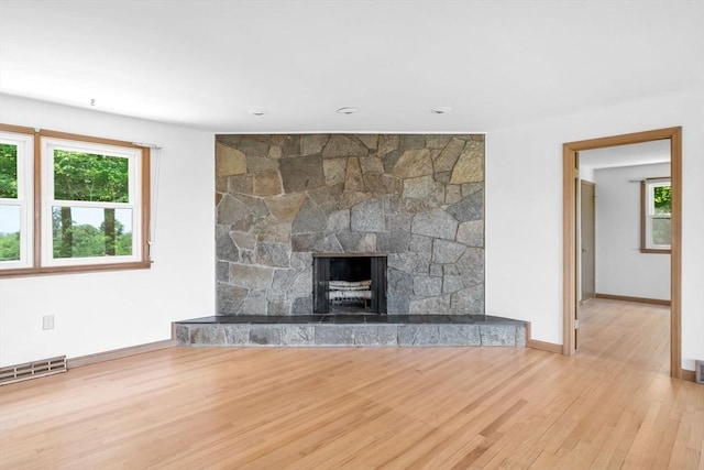 24 Skyridge Dr, Somers, CT 06071 - unfurnished living room featuring healthy amount of natural light, wood finished floors, baseboards, and a stone fireplace