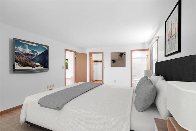 24 Skyridge Dr, Somers, CT 06071 - bedroom featuring wood finished floors, baseboards, a spacious closet, and ensuite bath