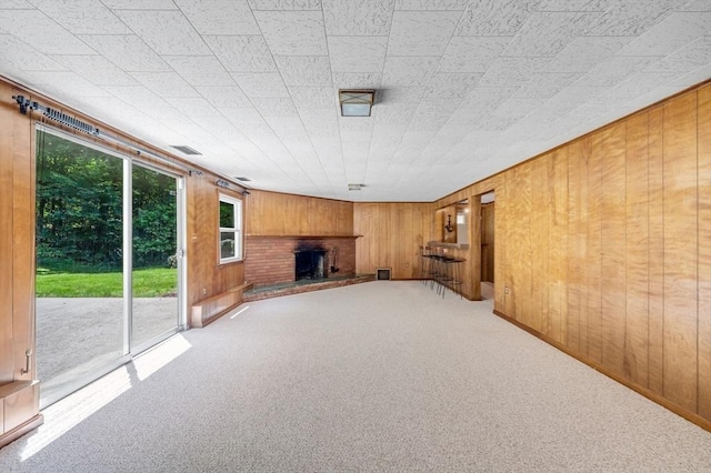 24 Skyridge Dr, Somers, CT 06071 - unfurnished living room with wood walls, a fireplace, and carpet
