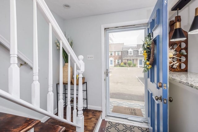 doorway featuring baseboards and stairway