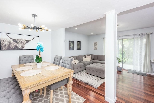 dining area with recessed lighting, wood finished floors, and a notable chandelier