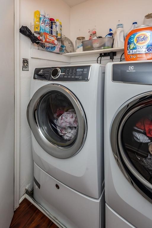 laundry area featuring laundry area, dark wood-style flooring, and washer and dryer