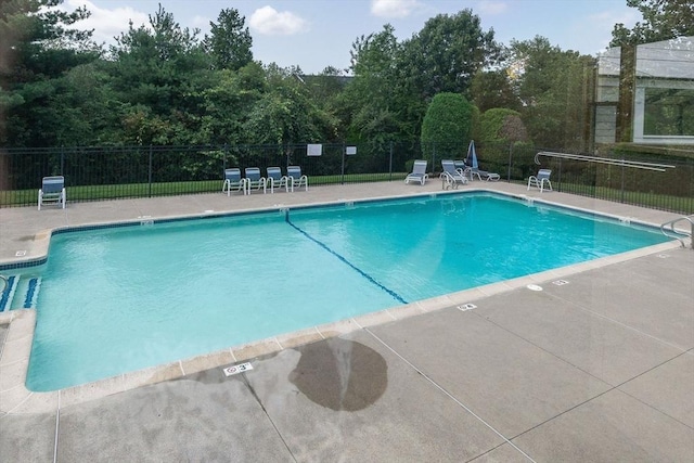 pool with a patio and fence