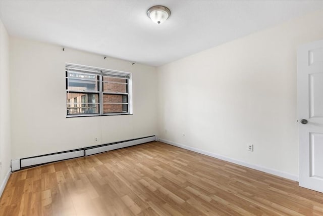 4925 Washington St Unit 304, Boston, MA 02132 - unfurnished room featuring baseboard heating and light wood-style flooring
