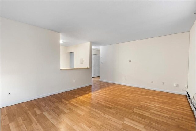 4925 Washington St Unit 304, Boston, MA 02132 - spare room with light wood finished floors and a baseboard heating unit