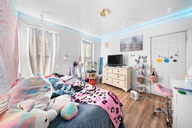 bedroom with hardwood / wood-style floors and crown molding