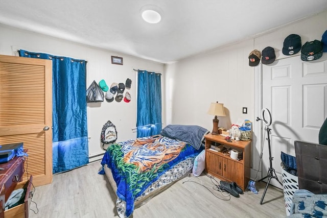 bedroom with a baseboard radiator and wood-type flooring