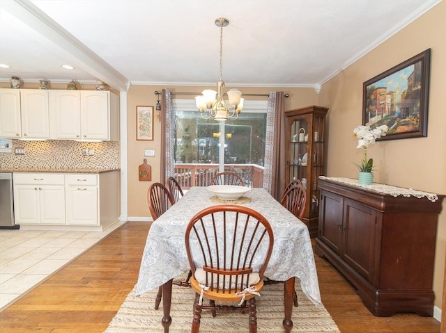 dining space featuring ornamental molding, a chandelier, and light wood-type flooring