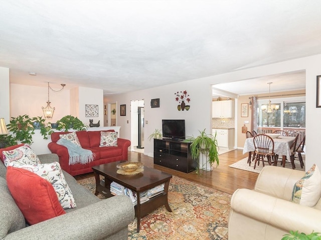 living room featuring a chandelier and light wood-type flooring