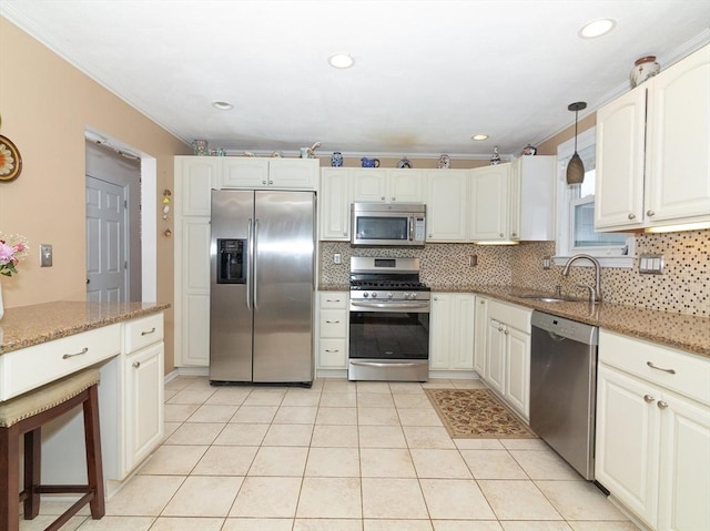 kitchen featuring appliances with stainless steel finishes, stone countertops, white cabinetry, decorative backsplash, and hanging light fixtures