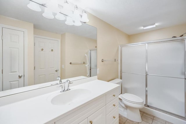 bathroom with vanity, toilet, tile patterned flooring, and a stall shower