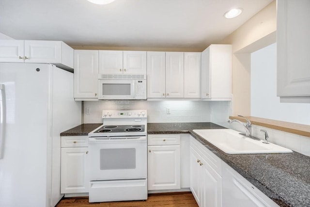 kitchen featuring a sink, backsplash, white appliances, and white cabinetry