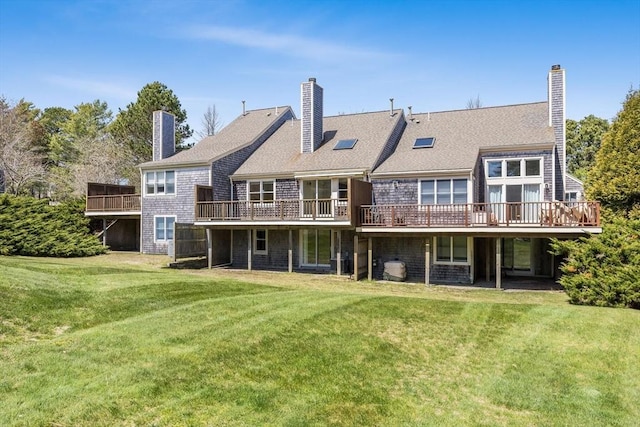 back of house featuring a yard, a chimney, and a wooden deck