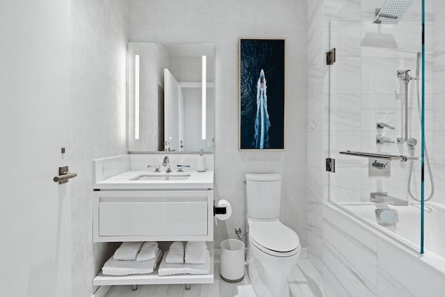 full bathroom featuring vanity, shower / bath combination with glass door, and toilet