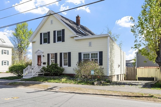 traditional-style house featuring fence and a chimney