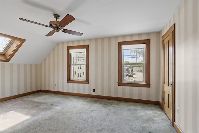 additional living space featuring carpet floors, a ceiling fan, and vaulted ceiling with skylight