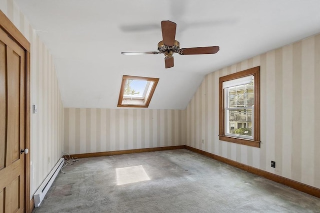 bonus room featuring carpet floors, a ceiling fan, vaulted ceiling with skylight, and a baseboard radiator