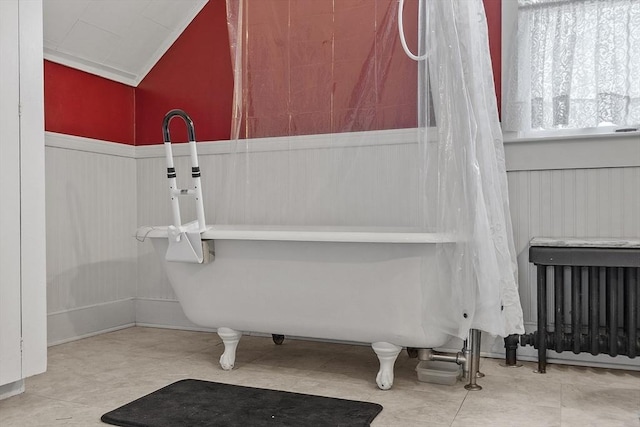 full bath with vaulted ceiling, a washtub, and wainscoting