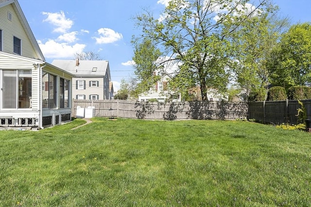 view of yard featuring a fenced backyard and a sunroom