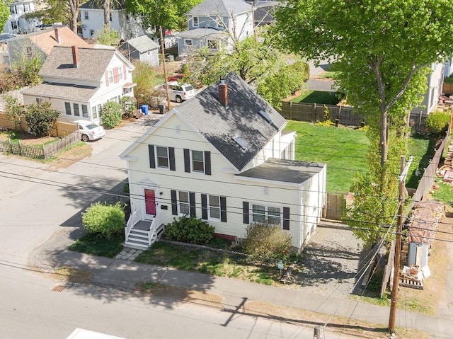 exterior space featuring fence, a residential view, and roof with shingles