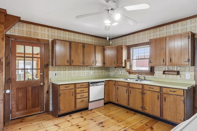 kitchen with a sink, dishwasher, light countertops, brown cabinetry, and wallpapered walls