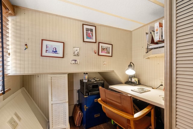 office space with a textured ceiling, built in desk, and dark hardwood / wood-style flooring