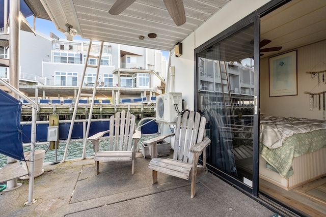 balcony with ac unit, a water view, and ceiling fan