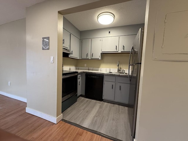 1186 Worcester Rd Unit 1221, Framingham, MA 01702 - kitchen with appliances with stainless steel finishes, a sink, light wood-type flooring, baseboards, and exhaust hood