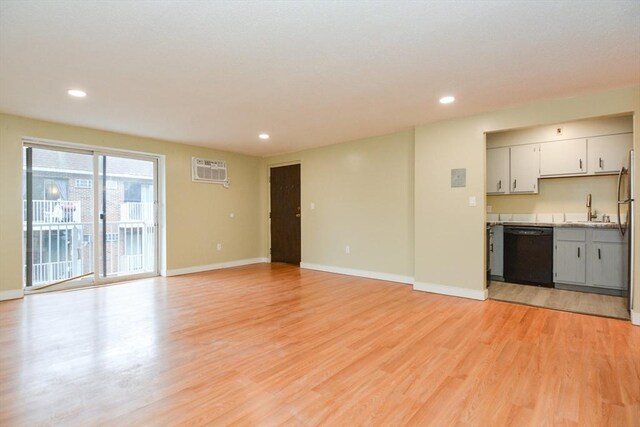 1186 Worcester Rd Unit 1221, Framingham, MA 01702 - unfurnished living room featuring light wood-style floors, recessed lighting, a wall mounted air conditioner, baseboards, and a sink