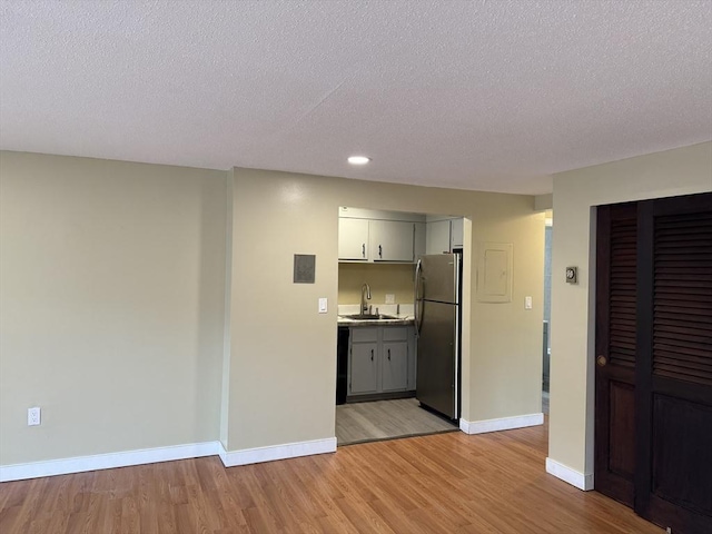 1186 Worcester Rd Unit 1221, Framingham, MA 01702 - bar area featuring freestanding refrigerator, a sink, light wood-style floors, baseboards, and a textured ceiling