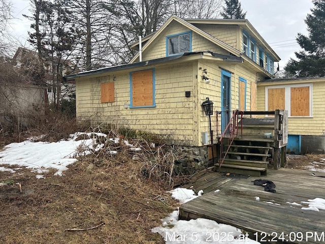 snow covered property with a deck