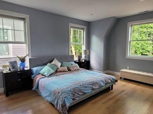 bedroom featuring multiple windows and light hardwood / wood-style flooring