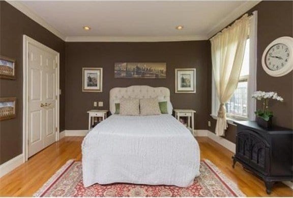 bedroom with light hardwood / wood-style flooring and crown molding