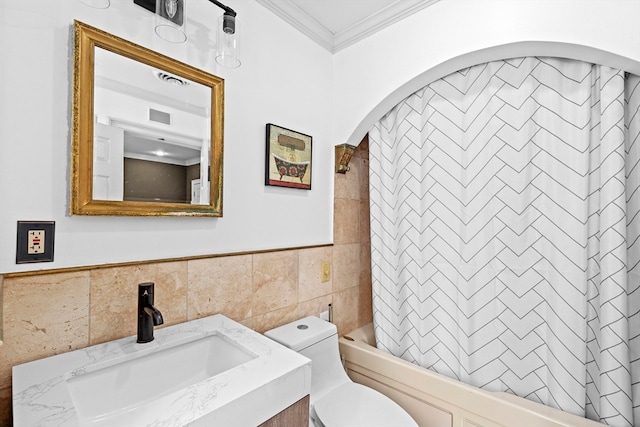 full bathroom featuring shower / bath combination with curtain, vanity, tile walls, crown molding, and toilet