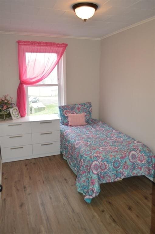bedroom featuring light wood finished floors and ornamental molding