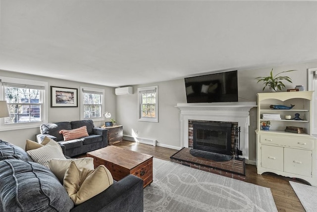 living room featuring a baseboard radiator, a fireplace, a wall mounted air conditioner, and wood finished floors