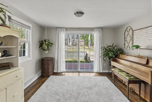 living area with baseboards and dark wood-style flooring