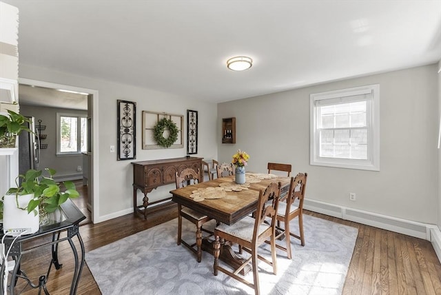 dining space featuring baseboards and dark wood-style flooring