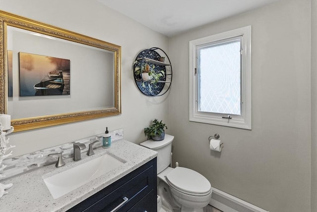 bathroom featuring vanity, baseboards, and toilet