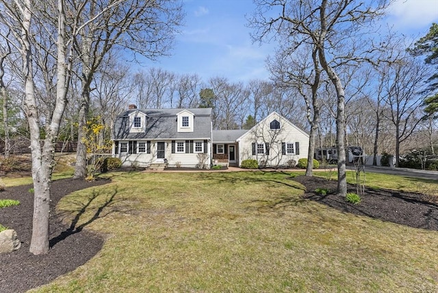 dutch colonial with a shingled roof, a chimney, and a front yard