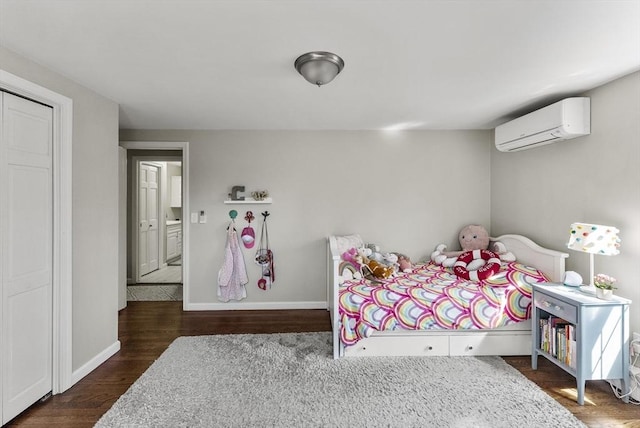bedroom featuring baseboards, a wall unit AC, and wood finished floors