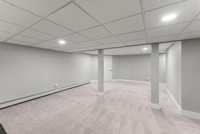 finished below grade area featuring a paneled ceiling, carpet floors, a baseboard radiator, baseboards, and recessed lighting