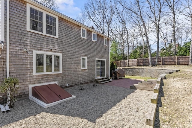 back of property with fence, a patio area, and entry steps
