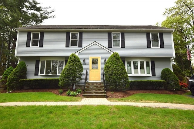 colonial home featuring entry steps and a front lawn