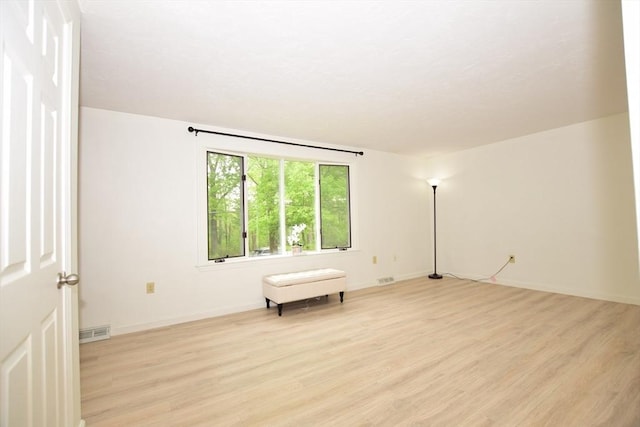 empty room featuring light wood finished floors and baseboards