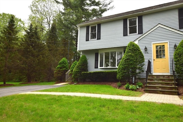 colonial inspired home featuring entry steps and a front lawn